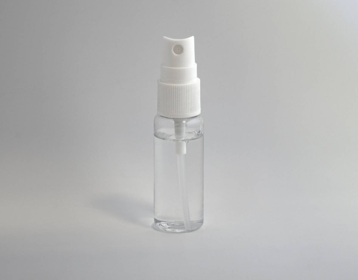 mini natural air freshener in a small glass vial with dried orange slices and sprigs of rosemary on a wooden windowsill