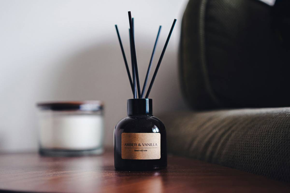 Natural luxury home air freshener setup with dried botanicals and essential oil diffuser on marble surface