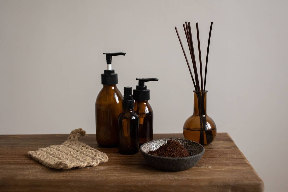 Glass spray bottle filled with water, vinegar, and citrus peels labeled natural room air freshener